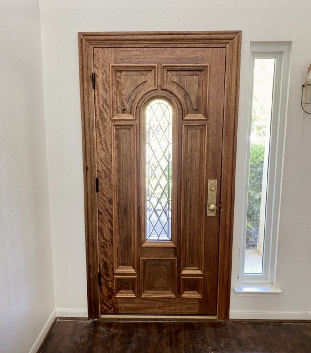 Stained wood arched door with leaded diamond glass